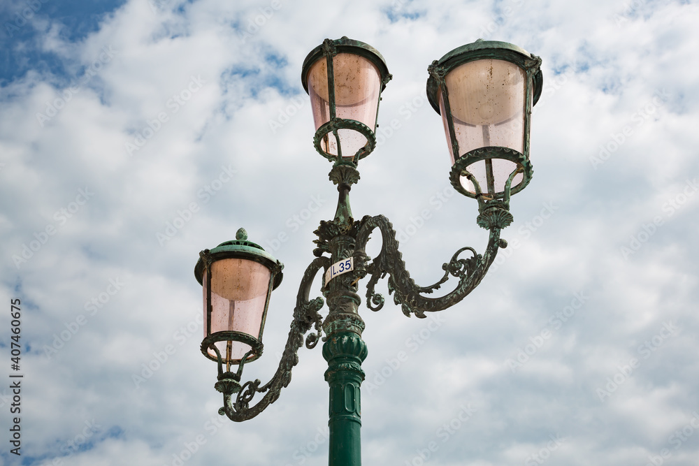 Typical 3-headed lanterns against cloudy sky, Venice, Italy