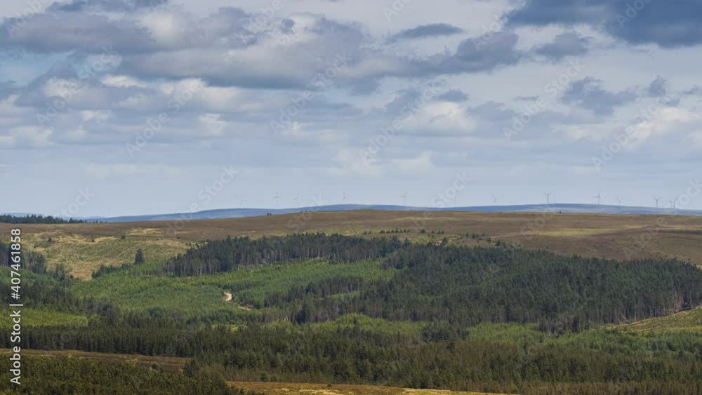 Time lapse of mixed forestry rural landscape and wind turbines on distant hills on a summer cloudy day in Ireland. Time lapse of mixed forestry rural landscape and wind turbines on distant hills on a summer cloudy day in Ireland.