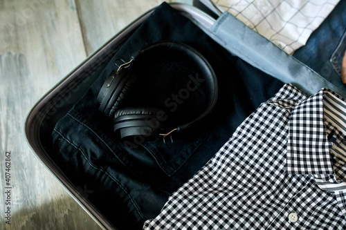 Packing suitcase at home with casual man items, stuff