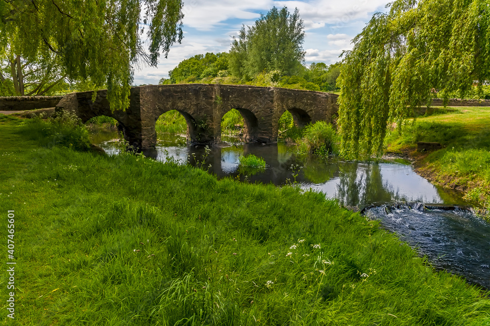 A view along the bank towards the old Packhorse Bridge on the outskirts of Anstey, Leicestershire in summertime