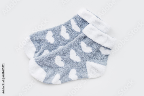 Pair of warm winter womens socks with print in the shape of hearts isolated on light gray background