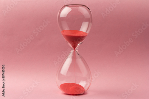 Crystal hourglass on pink background as a concept of passing time for business term, urgency and outcome of time.