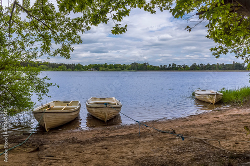 A view of boats moored on the shoreline of the Cropston Reservoir in Leicestershire in summertime photo