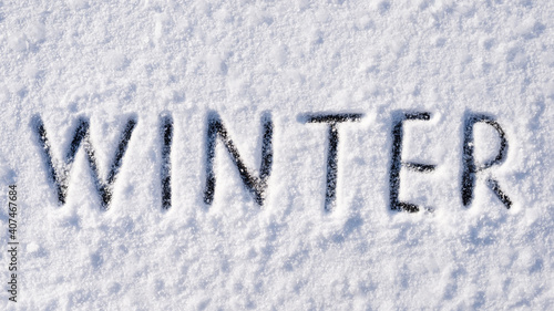 Winter inscription on white snow surface. Concept of winter season © Vitalii
