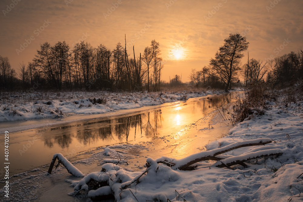 Sunset over the Jeziorka river at winter near Piaseczno, Masovia, Poland