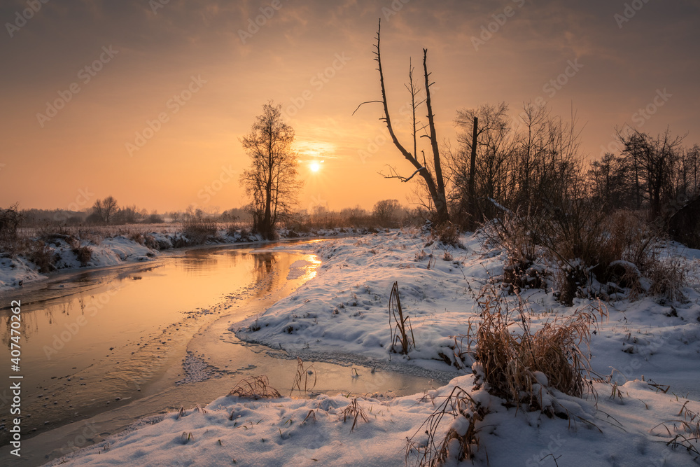 Sunset over the Jeziorka river at winter near Piaseczno, Masovia, Poland