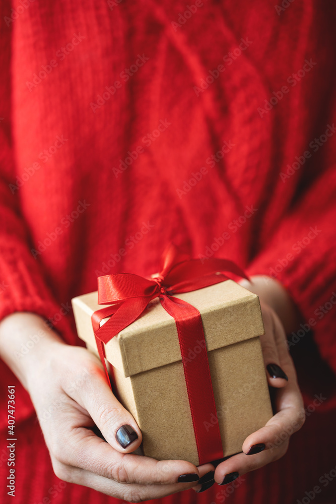 Female hands holding a gift. Close up view.