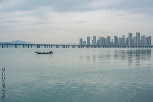 The fishing boats in the bay by Xiamen bridge, on a cloudy day. © Zimu