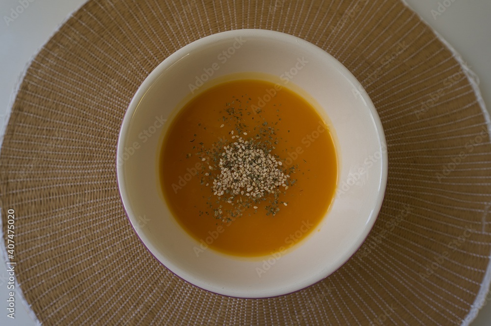 pumpkin cream with sesame and spices into a white bowl in natural fiber background. Healthy food concept pumpkin cream with sesame and spices into a white bowl in natural fiber background. Healthy food concept