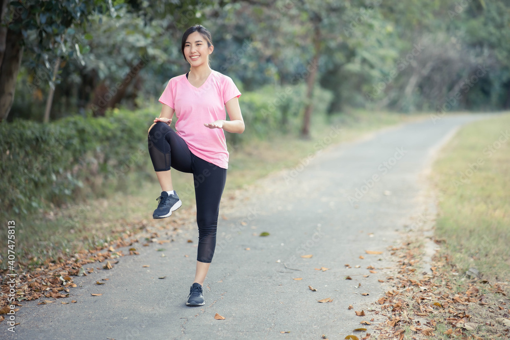Asian girl is stretching her body warm muscles before going out for a run at the park Asian girl is stretching her body warm muscles before going out for a run at the park