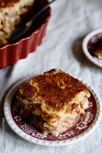 Apple and Cheese Cobbler Crisp. Cobbler or Crumble dessert with apples in ceramic baking form on beige linen table. Selective focus photo