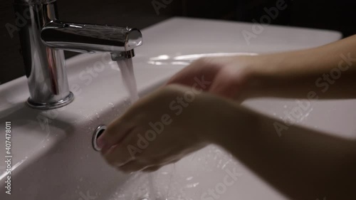 Woman picks up tap water and washes her face