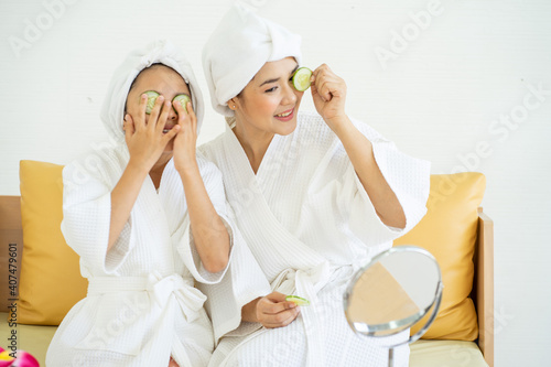 Asian young girl wearing bathrobe with mother with home spa ingredient at home