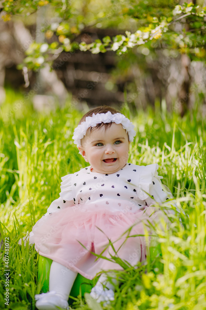 Happy six months old baby full of happiness smiling in garden Happy six months old baby full of happiness smiling in garden