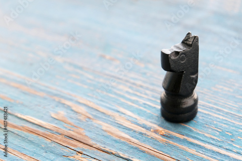 Knight, figure, chess on a blue old wooden background. 
