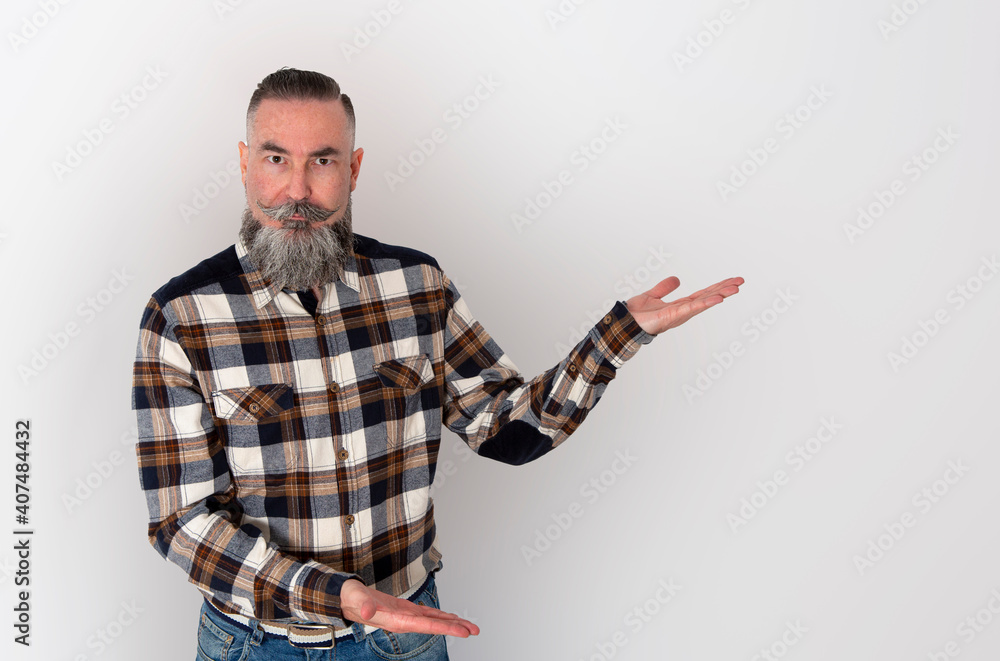 man with a big beard and mustache, plaid shirt with his hands pointing to the side where the copy space is located to put your logo, text or advertisement man with a big beard and mustache, plaid shirt with his hands pointing to the side where the copy space is located to put your logo, text or advertisement