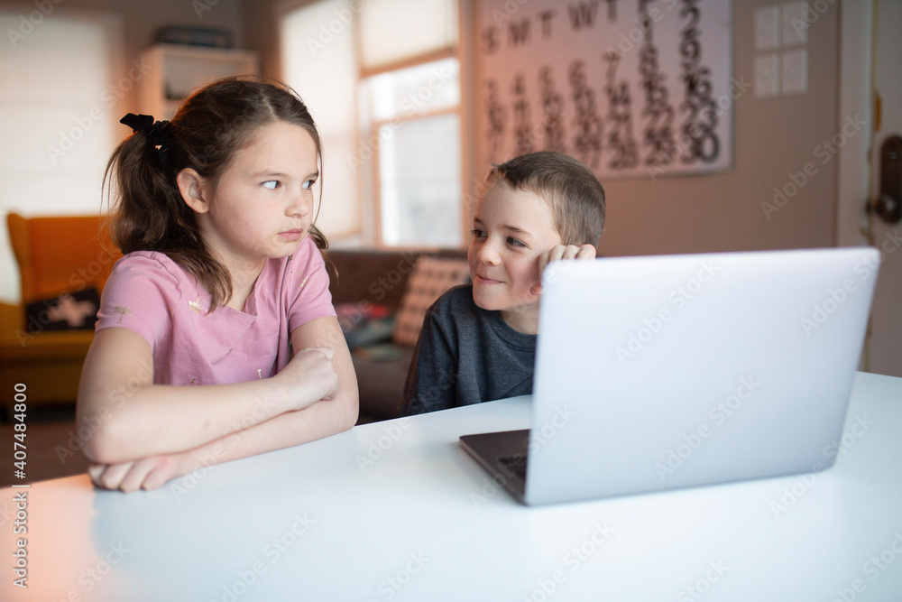boy and girl looking at a laptop with a worried and confused look boy and girl looking at a laptop with a worried and confused look