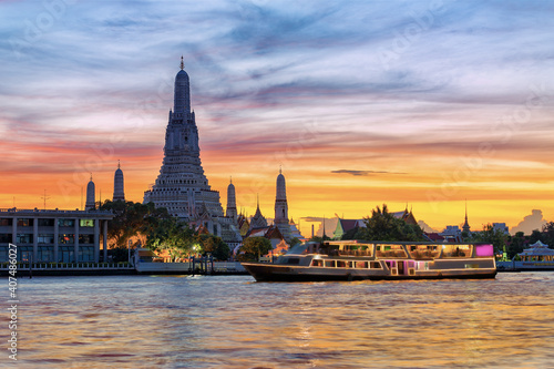 Chao Phraya River Cruise Boat with Temple of the Dawn, Wat Arun, at Sunset in Background, Horizontal photo