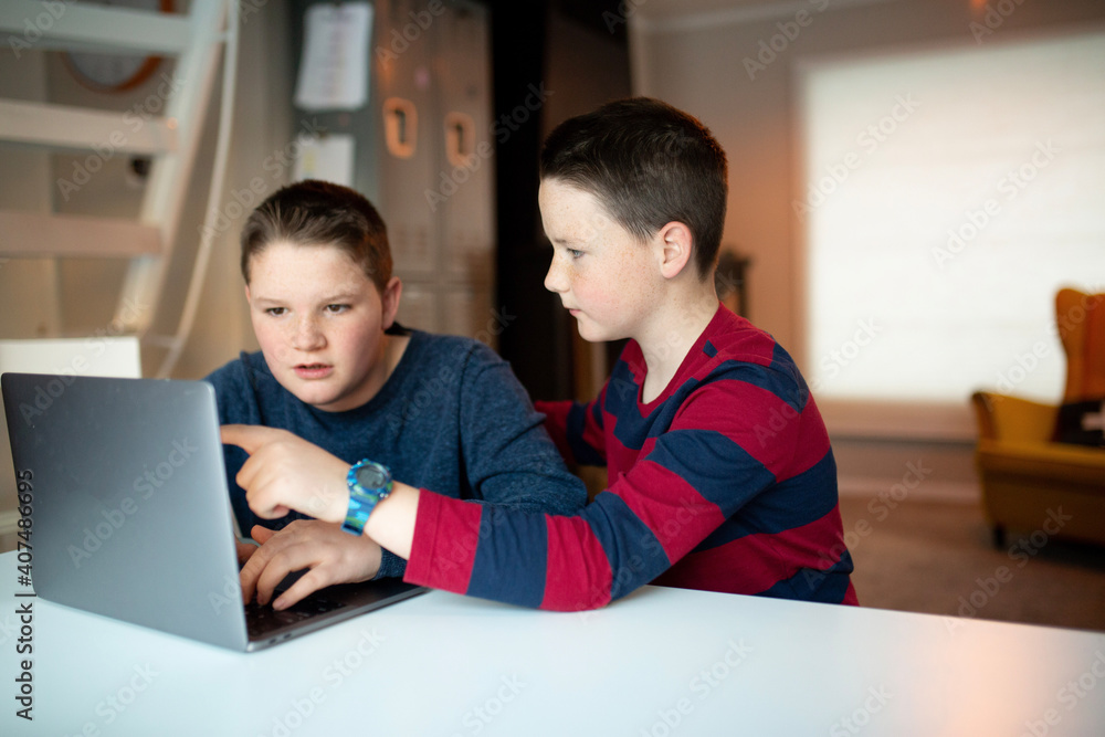 boys looking at a laptop with a worried and confused look boys looking at a laptop with a worried and confused look