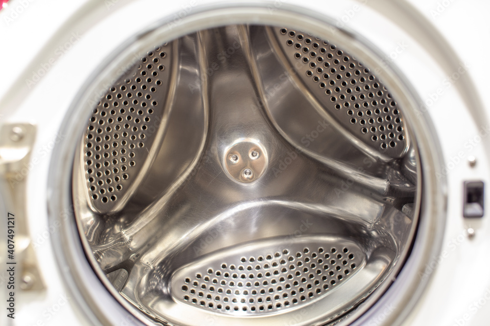 The washing machine drum is dry and clean close-up. Washer The washing machine drum is dry and clean close-up. Washer