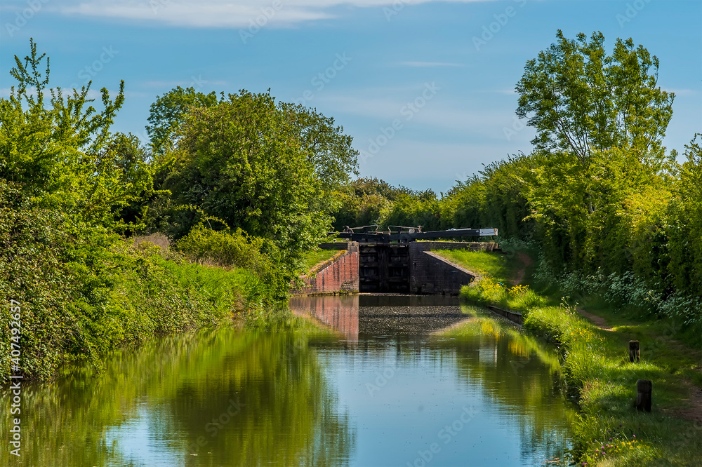 A view up the Oxford canal towards a lock gate at the village of Napton, Warwickshire in summertime A view up the Oxford canal towards a lock gate at the village of Napton, Warwickshire in summertime