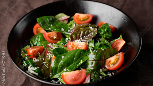 salad with tomatoes, arugula, spinach, cheese parmesan close up. healthy lifestyle concept 