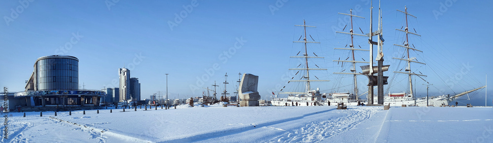 Gdynia, Poland - January 17, 2021: Polish sailing ship SV Dar Mlodziezy at the waterfront in Gdynia in winter time. The most famous city landscape. Panoramic photo. Gdynia, Poland - January 17, 2021: Polish sailing ship SV Dar Mlodziezy at the waterfront in Gdynia in winter time. The most famous city landscape. Panoramic photo.