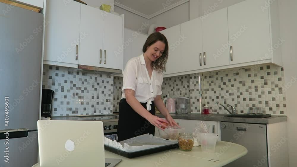 Beautiful young woman baking with her friends on video chat during lockdown. Quarantine concept. Beautiful young woman baking with her friends on video chat during lockdown. Quarantine concept.