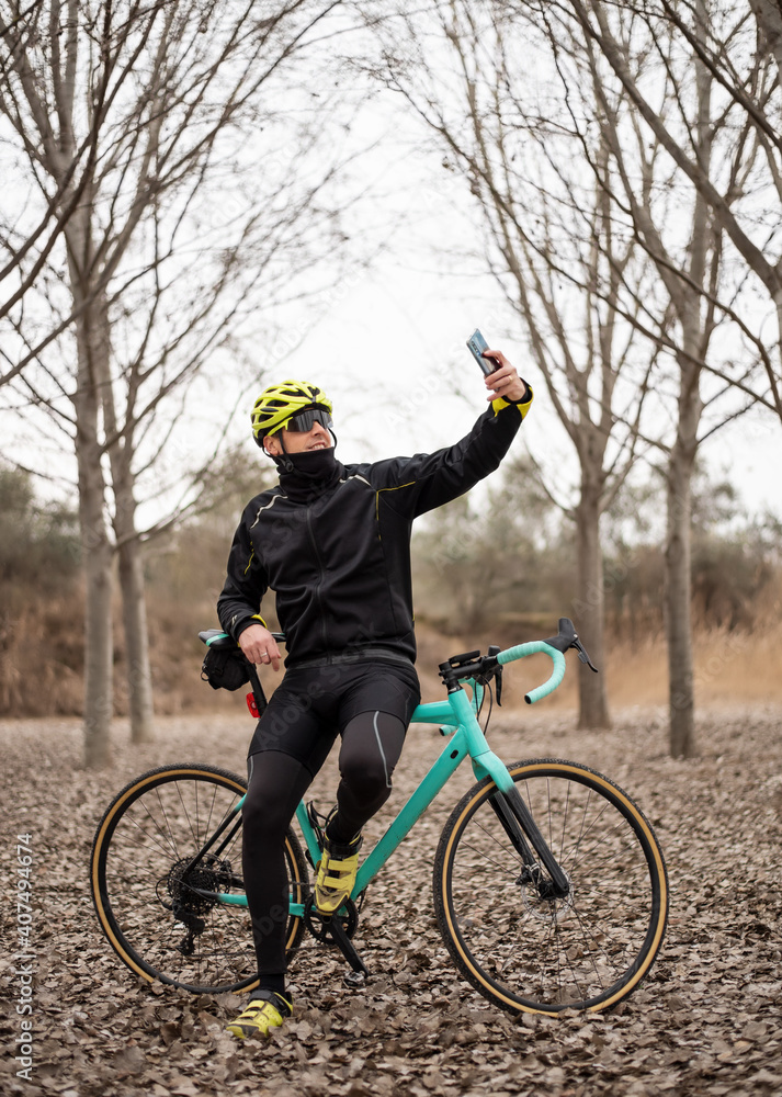Hombre consultando GPS en su smartphone explorando mapas mientras monta en bicicleta. - obrazy, fototapety, plakaty 