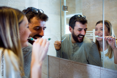 A cute couple brushing teeth