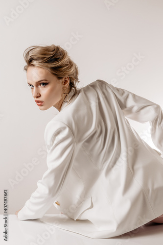 Beauty portrait of a girl with white hair, makeup and hairstyle on a white background