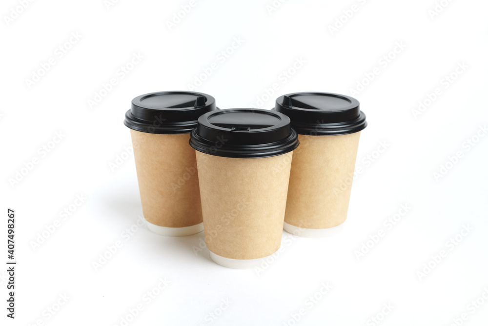 Many eco friendly paper craft cups for coffee to go with black lid on the white background. Zero waste, plastic free concept. Sustainable lifestyle. Composition with front view. Many eco friendly paper craft cups for coffee to go with black lid on the white background. Zero waste, plastic free concept. Sustainable lifestyle. Composition with front view.