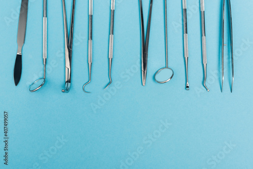 Top view of dental mirrors and tools on blue background