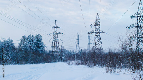 Power transmission lines in coniferous forest in winter. Winter landscape with high voltage power lines.
