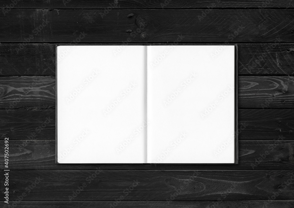 Blank open notebook isolated on black wood background Blank open notebook isolated on black wood background