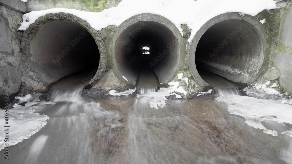 Three concrete drainage pipes that remove melted snow and ice, timelapse. Three concrete drainage pipes that remove melted snow and ice, timelapse.
