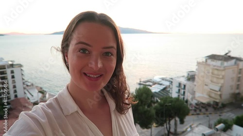 Young enthusiastic travel vlogger showing her followers the beautiful beach in Europe.