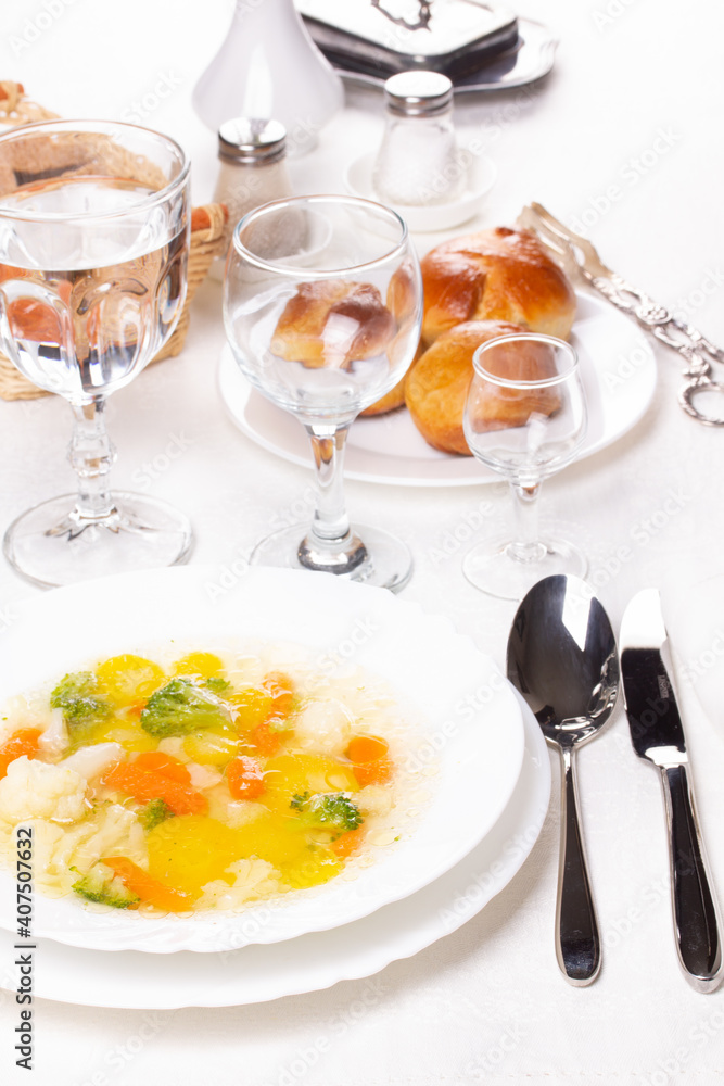 Fresh hot vegetable soup in a white plate on the table