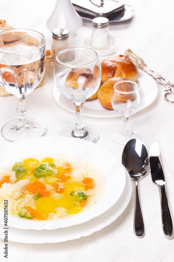 Fresh hot vegetable soup in a white plate on the table Fresh hot vegetable soup in a white plate on the table