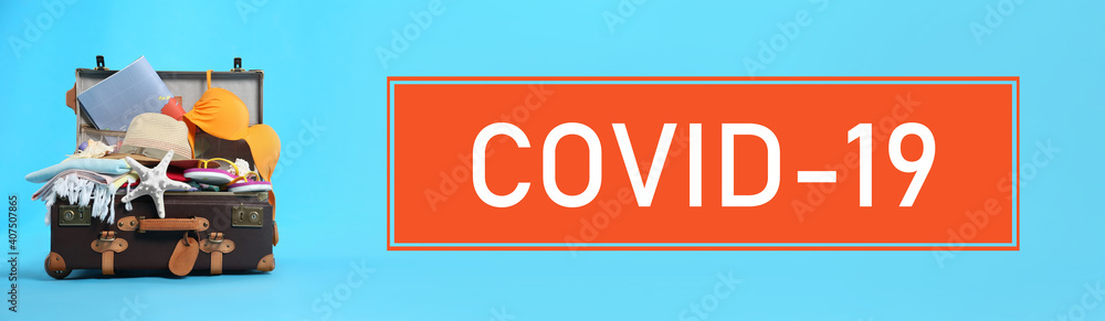 Coronavirus pandemic, lockdown measures. Packed travel suitcase and text COVID-19 on blue background, banner design Coronavirus pandemic, lockdown measures. Packed travel suitcase and text COVID-19 on blue background, banner design