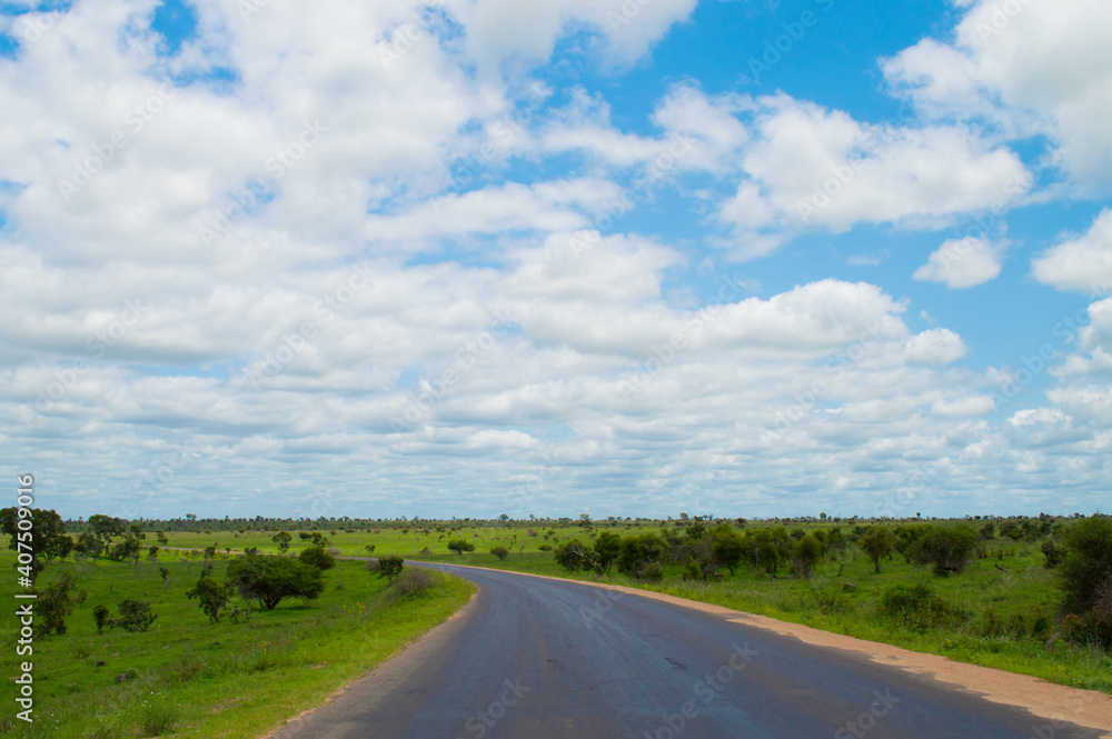 Straße mit Kurve in der grünen Landschaft Südafrikas mit viel weiß blauem Himmel bis zum Horizont Straße mit Kurve in der grünen Landschaft Südafrikas mit viel weiß blauem Himmel bis zum Horizont