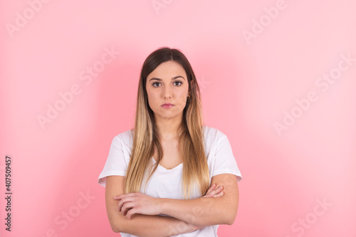 young woman with her arms crossed and a serious look on her face