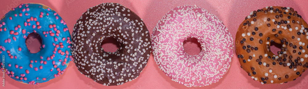 Sweet delicious donuts on a pink background