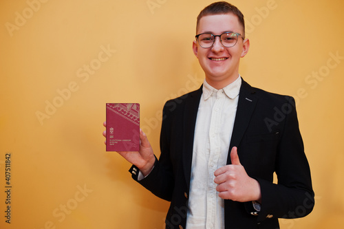 Canvas Print Young handsome man holding Kingdom of Sweden passport id over yellow background, happy and show thumb up