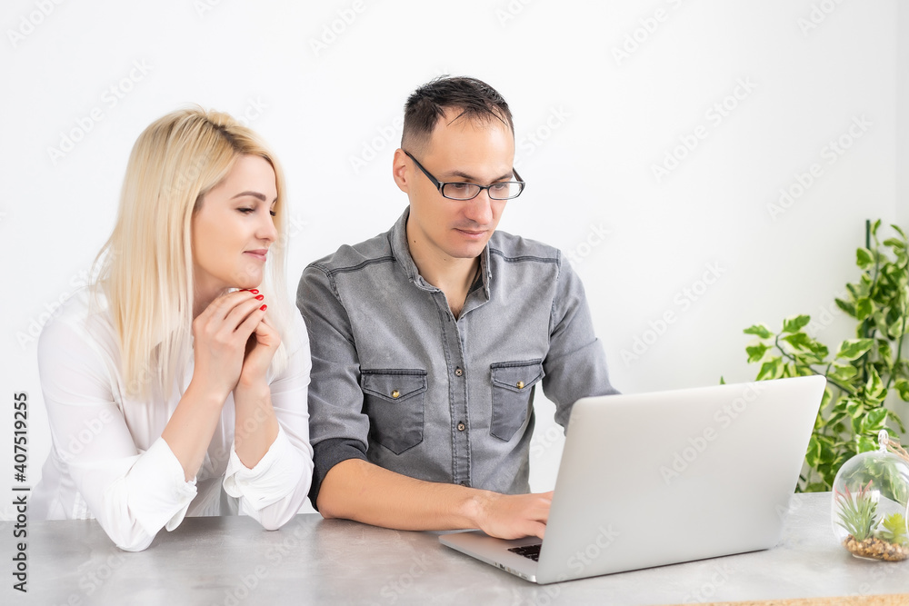 Couple working on laptop in office, woman and man with laptop Couple working on laptop in office, woman and man with laptop