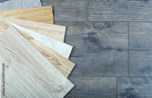 Vinyl and linoleum samples on a wooden background. Vinyl for flooring with wood grain texture and pattern.
