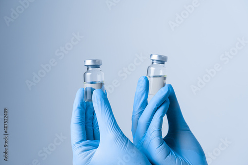 2 doses of coronavirus vaccine. Close-up covid-19 Vaccination. Woman in blue medical gloves holding medication.