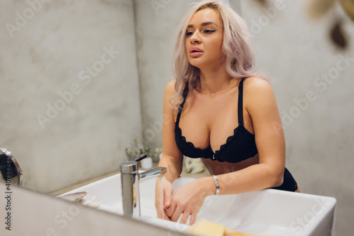 Fotografie beautiful brunette woman in bikini sitting under shower