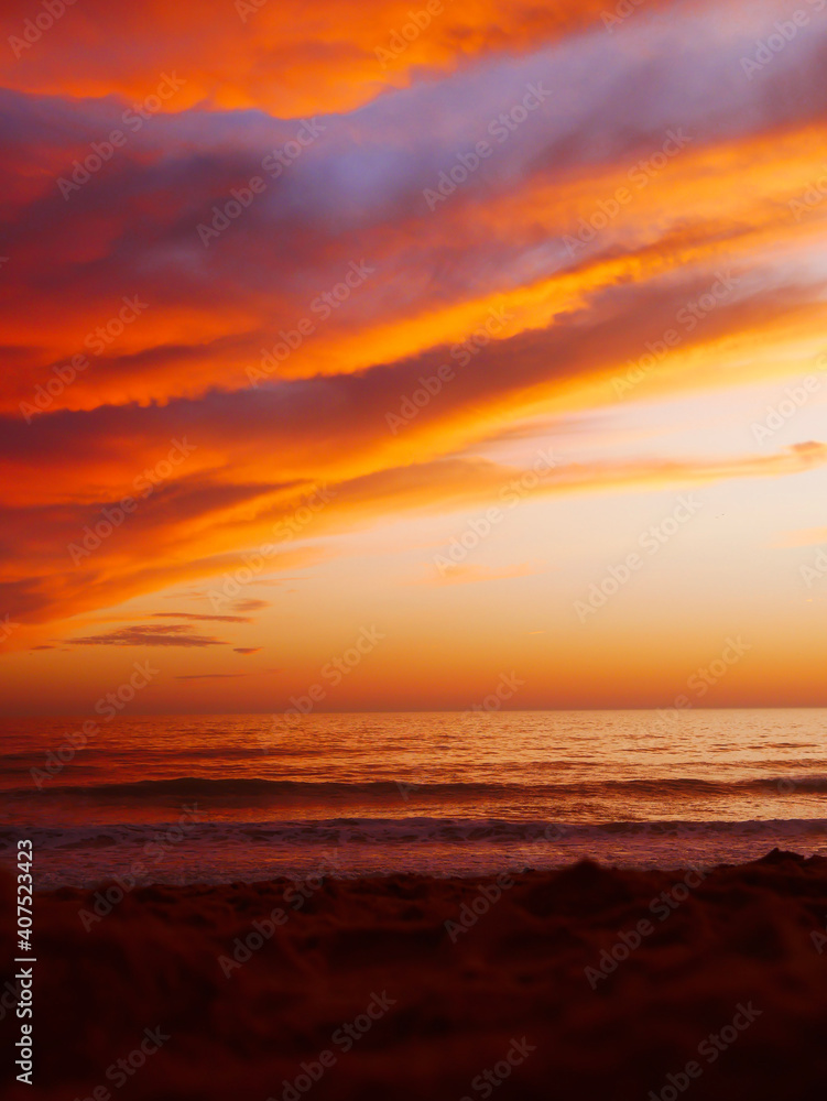 Colorful cloudy sunset on the beach with the sea and the  horizon