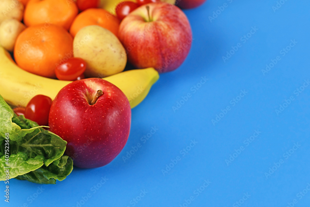Red apple and lettuce with other fruits and vegetables in blurry blue background with empty copy space Red apple and lettuce with other fruits and vegetables in blurry blue background with empty copy space